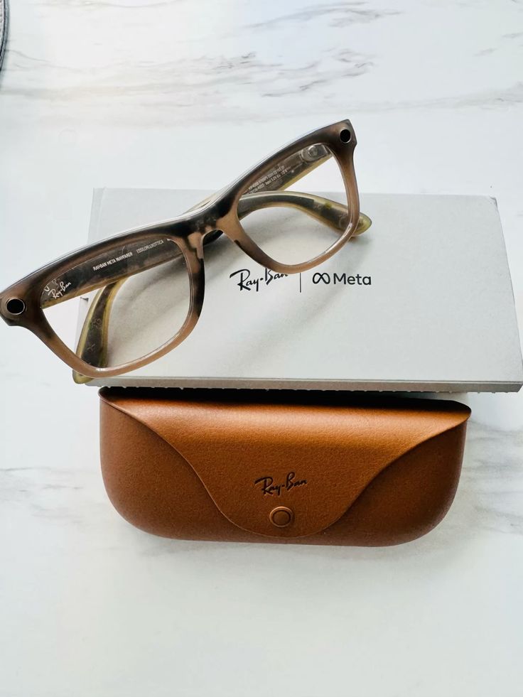 Ray-Ban Meta smart glasses brown translucent frame clear lenses displayed on Ray-Ban Meta box with brown leather case